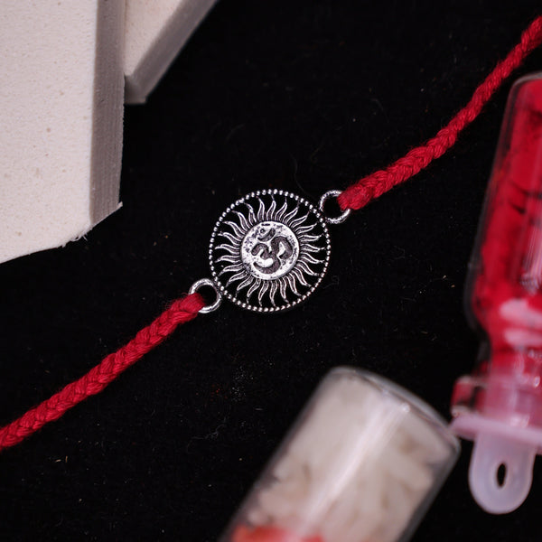 A Rakhi bracelet with a 925 silver Om symbol , displayed on a dark background.
