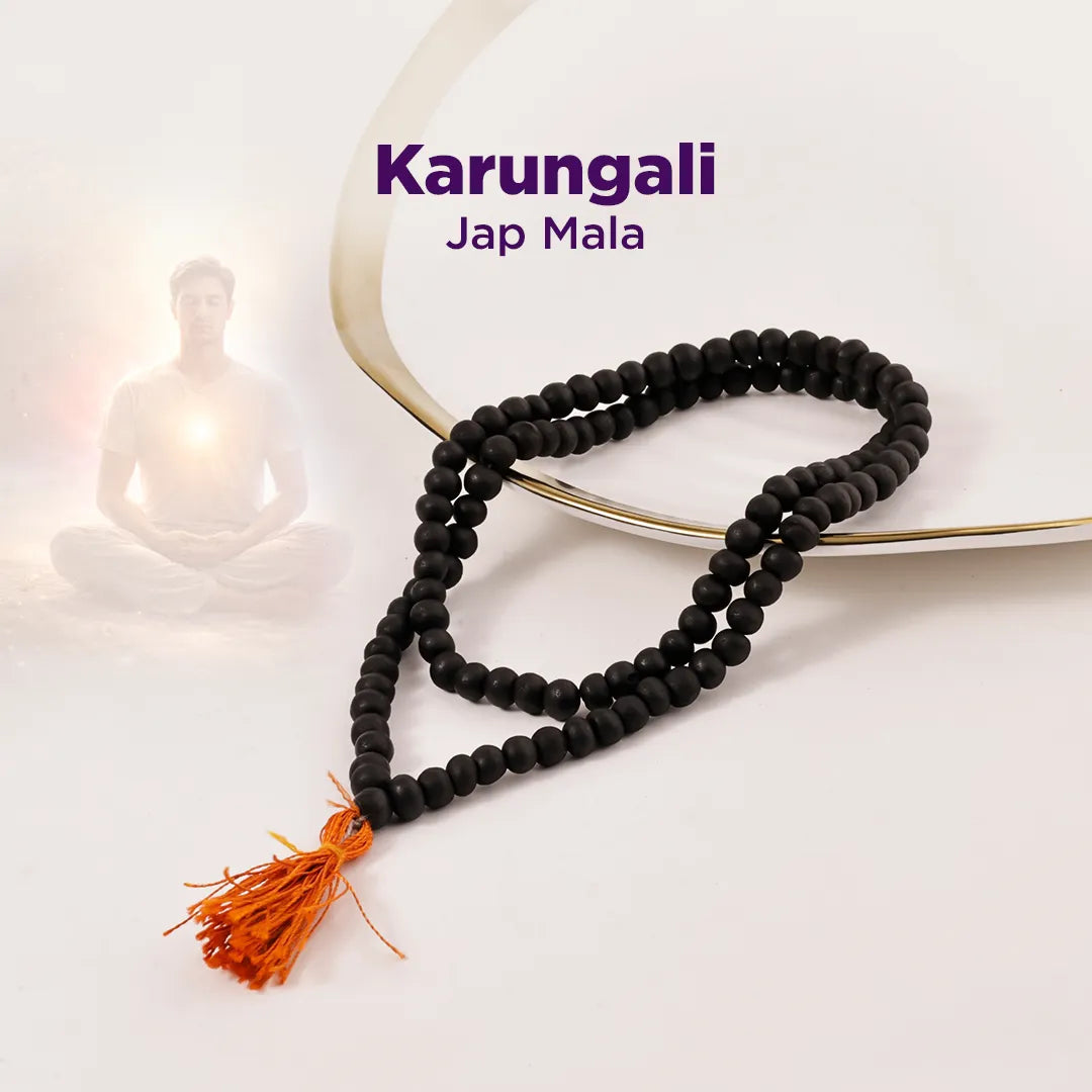 Black Jap Mala with an orange tassel on a white background, featuring the brand 'Karungali'.