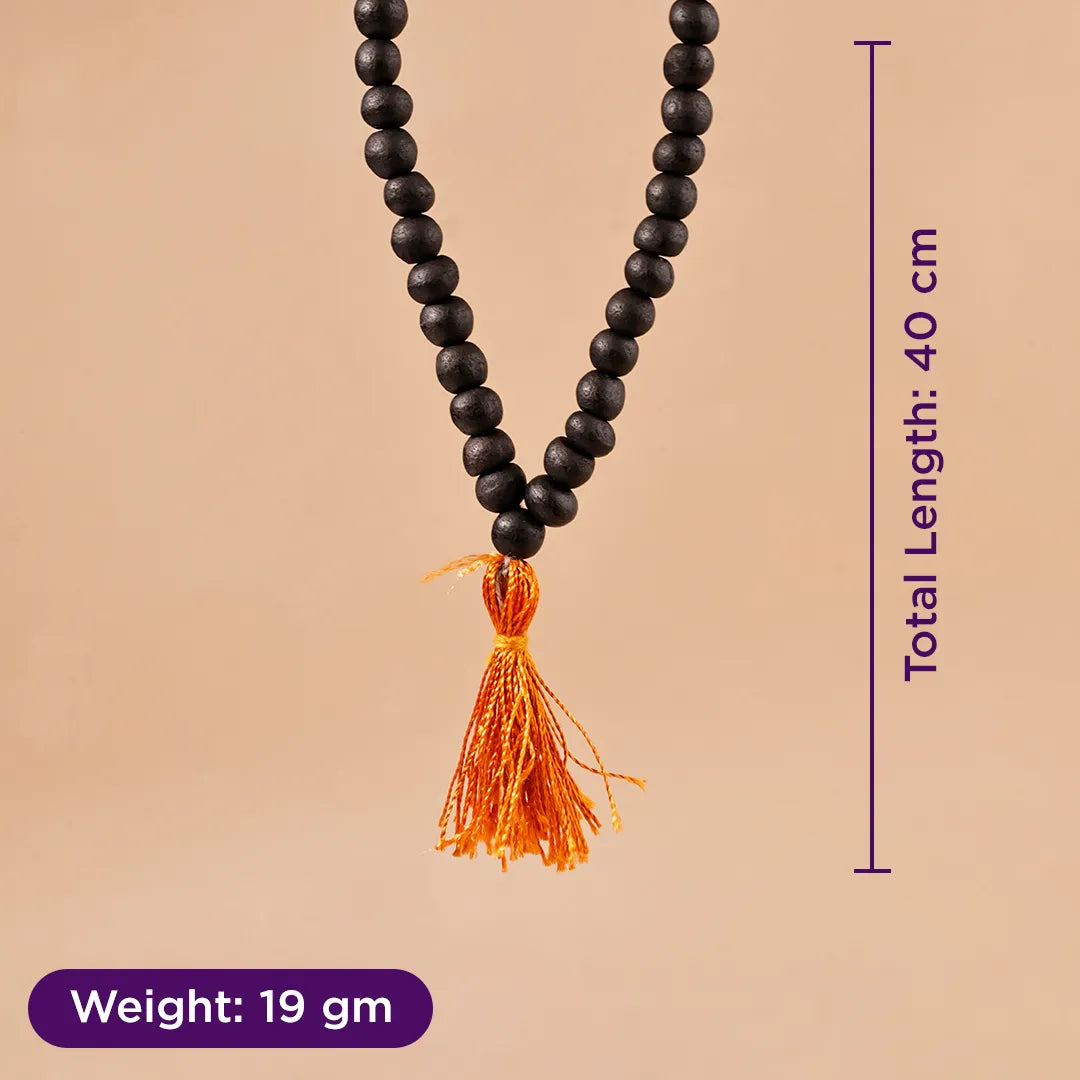 Black beaded necklace with orange tassel on a beige background, showing weight and length information.Karungali Jap Mala (Ebony Wood) for Meditation, Protection & Spiritual Focus