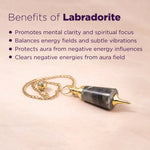 Labradorite pendulum with benefits listed on a pink background