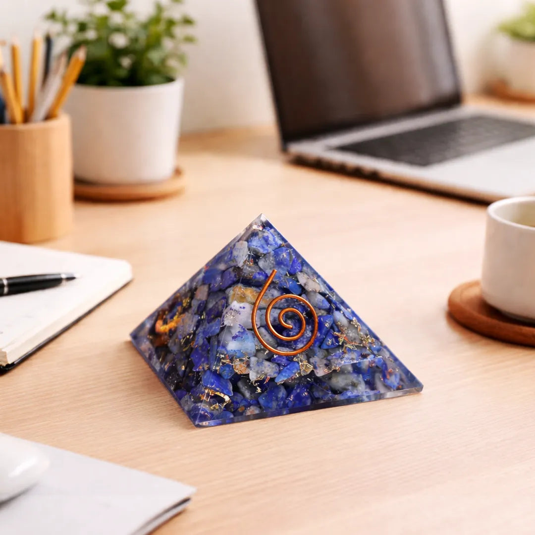 Decorative crystal pyramid with a spiral on a desk with laptop, notebook, and cup.Lapis Lazuli Pyramid – Communication, Wisdom & Confidence Crystal