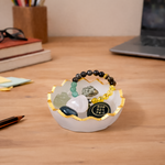 Decorative bowl with stones and a bracelet on a wooden desk