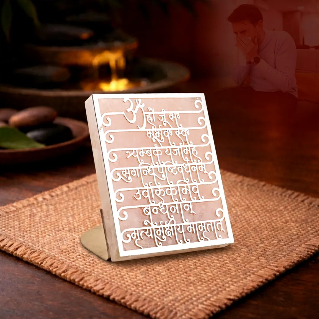 Decorative sign with text on a stand in a warm-toned indoor settingMaha Mrityunjaya Mantra Rose Quartz Candle Stand for Protection & Healing