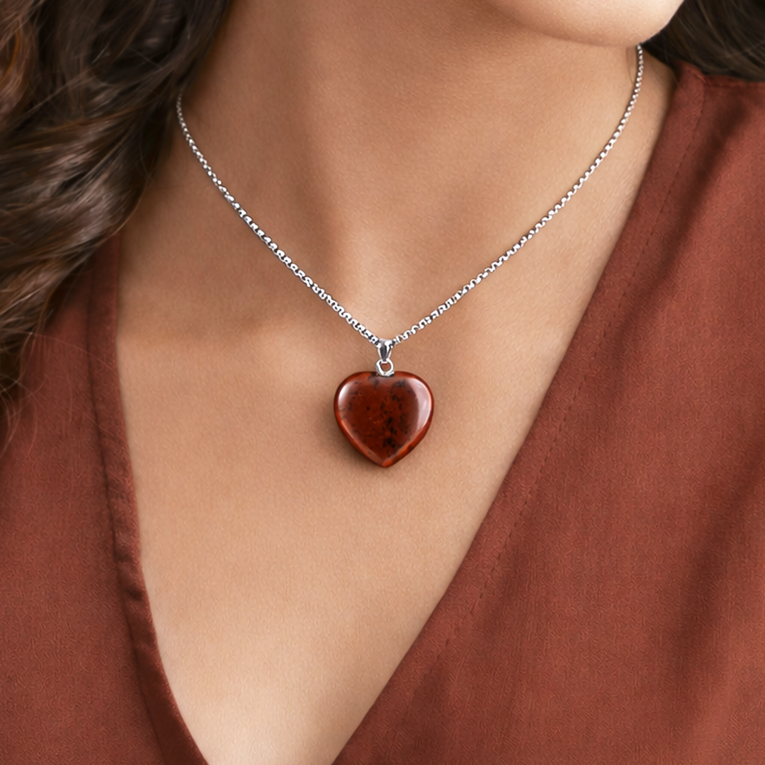 Heart-shaped pendant necklace on a person wearing a rust-colored topMahogany Obsidian Heart Pendant (Abhimantrit) for Protection & Strength