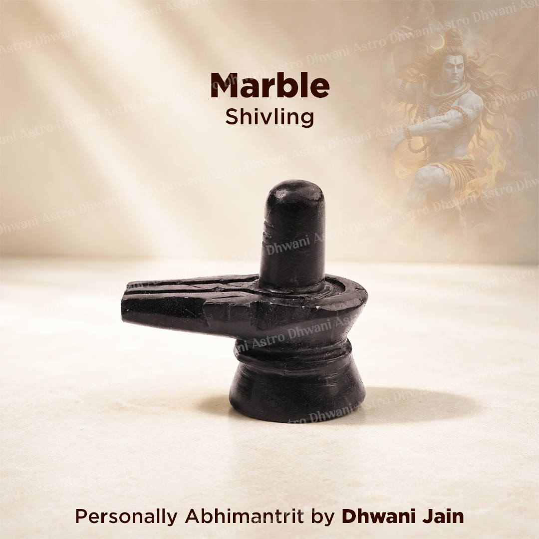 A black marble Shivling statue displayed on a light beige surface with a soft, warm background and text overlays reading 'Marble Shivling' and 'Personally Abhimanitrit by Dhwani Jain'.Natural Black Marble Shivling | Handcrafted Shiva Lingam for Home Temple, Puja & Meditation | Sacred Marble Shivling Idol