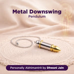 Metallic pendulum on a soft fabric background with text indicating brand and product name.