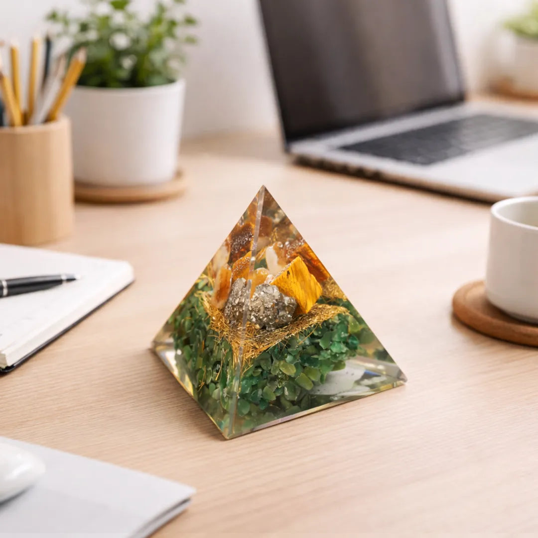 Pyramid-shaped decorative object on a desk with a laptop and office supplies in the background
