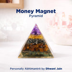 Crystal pyramid with colored stones on a white surface, labeled 'Money Magnet Pyramid' by Dhwani Jain.