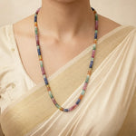 Multicolored beaded necklace worn by a person in a beige outfit