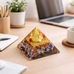 Decorative pyramid with colorful stones on a desk with laptop and office supplies