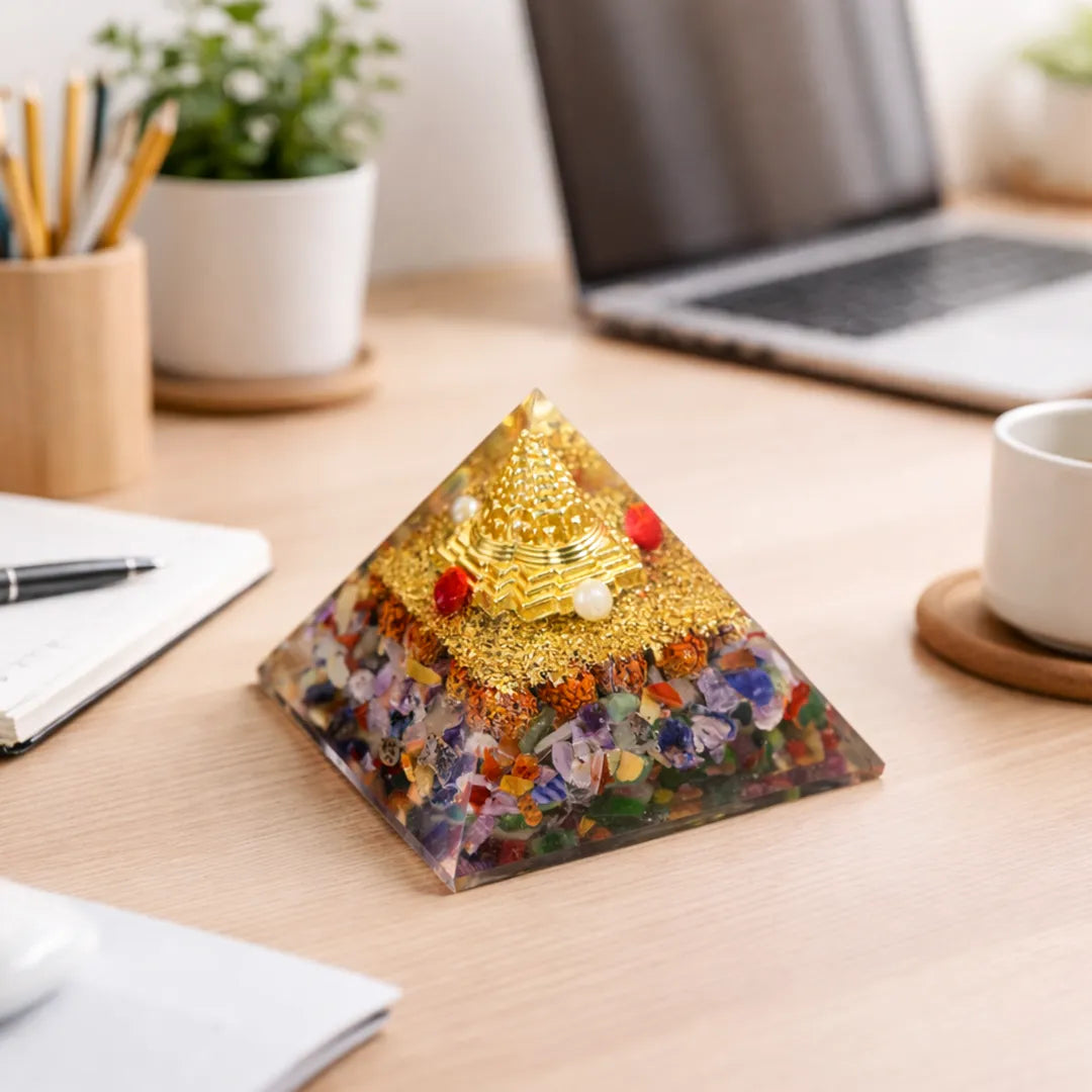 Decorative pyramid with colorful stones on a desk with laptop and office suppliesNav Grah Pyramid – Nine Planet Balance & Protection Energy