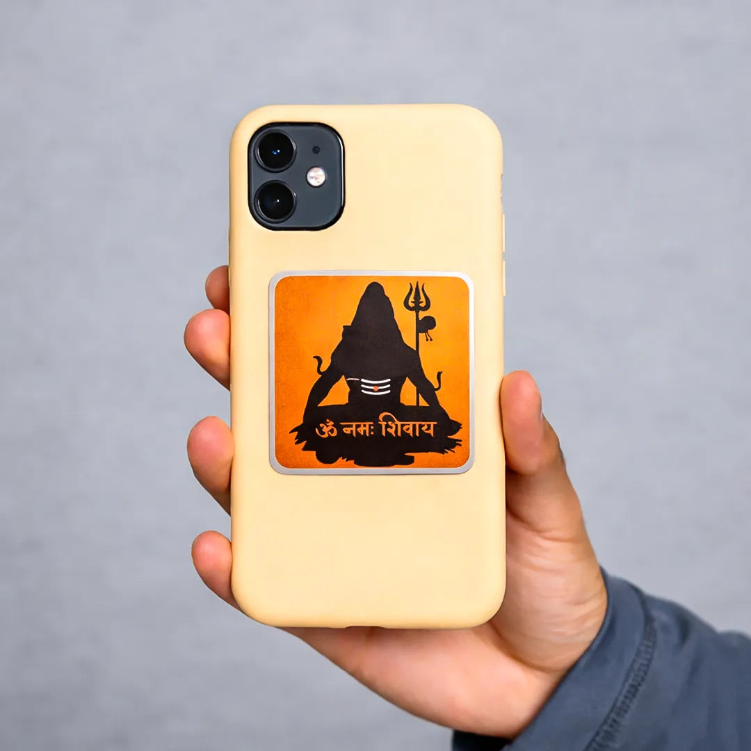 Hand holding a yellow phone case with a black and orange design on a gray background