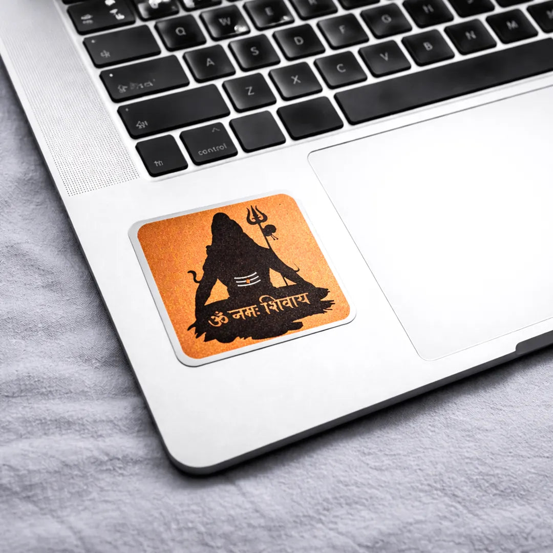 Laptop with a sticker of a black silhouette on an orange background