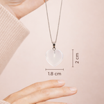 Heart-shaped pendant necklace on a chain, held by a hand with measurements displayed.