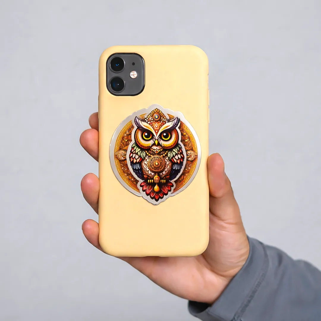 Hand holding a yellow phone case with an owl design on a gray background