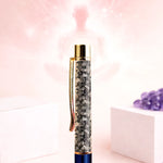 Decorative pen with gemstone accents on a soft pink background