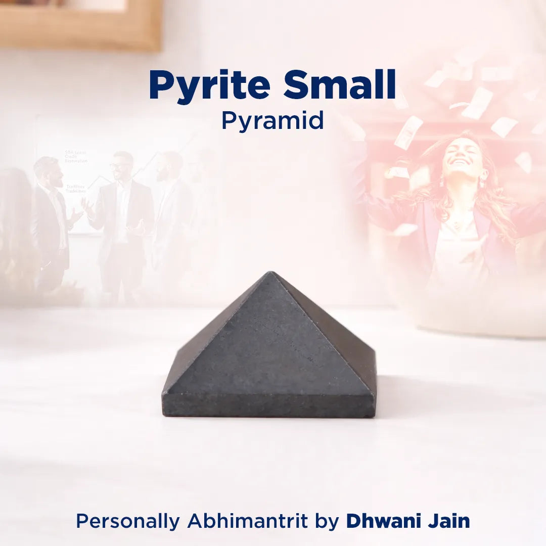 Small pyrite pyramid on a white surface with a blurred background