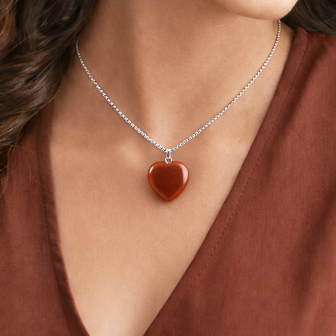 Heart-shaped pendant necklace on a person wearing a brown topRed Jasper Heart Pendant (Abhimantrit) for Strength & Grounding