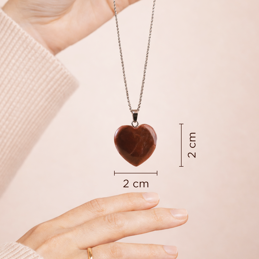 Heart-shaped pendant necklace with measurements on a plain background