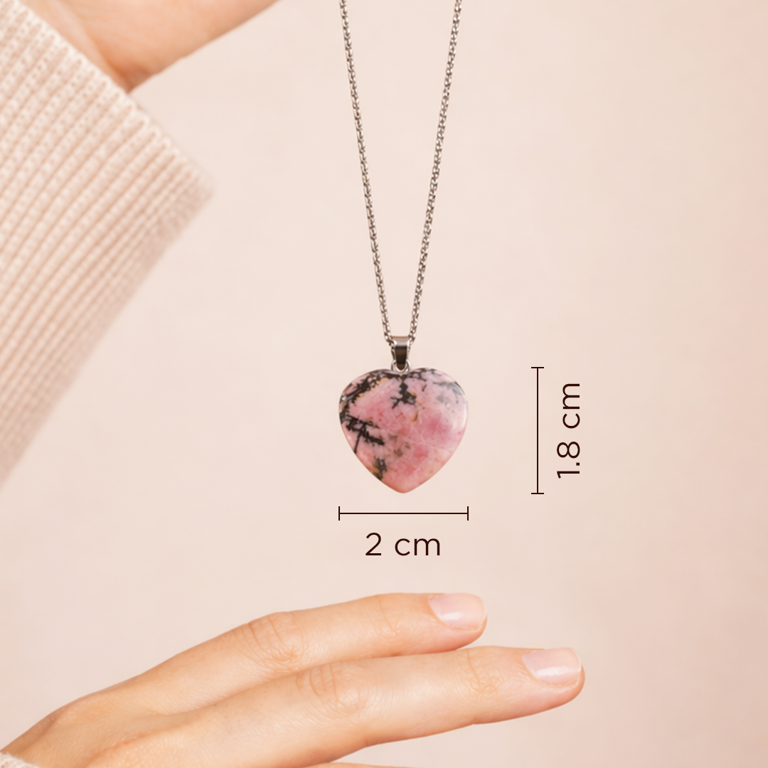 Necklace with a pink heart-shaped pendant held by a hand, with measurements displayed.Rhodonite Heart Pendant (Abhimantrit) for Emotional Healing & Balance