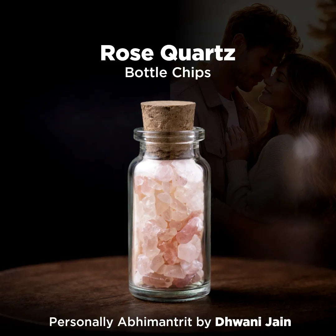 Glass bottle with rose quartz chips and cork lid on a dark background with a couple embracing.
