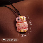Pink owl-shaped pendant with measurements and weight on a brown background