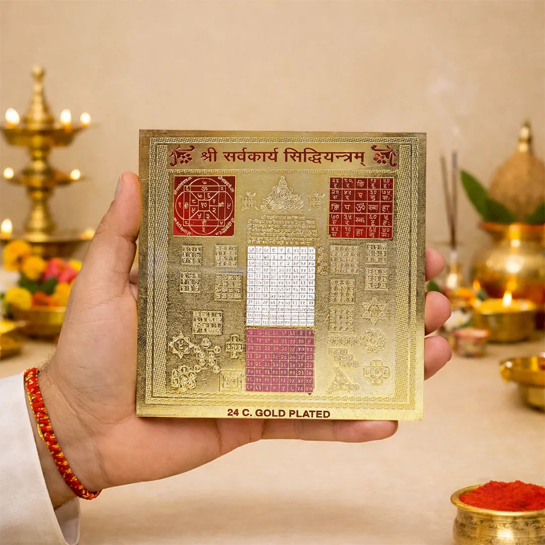 Gold-plated religious text card held by a hand with a blurred background of religious items.