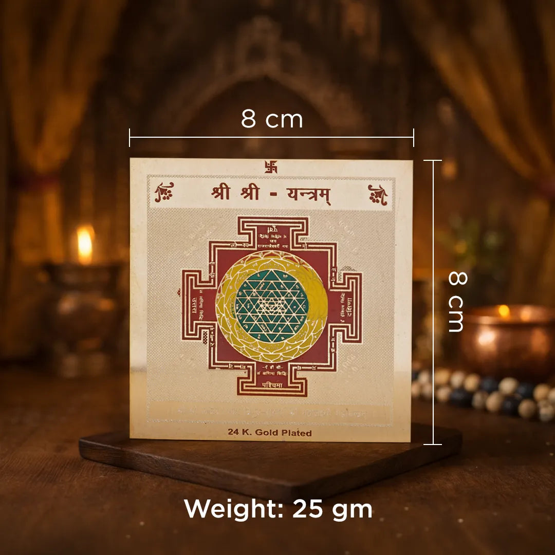 Decorative panel with a symbol and measurements on a wooden stand with a blurred background.Shree Shree Yantra – 24K Gold Plated Sacred Prosperity & Spiritual Energy Yantra