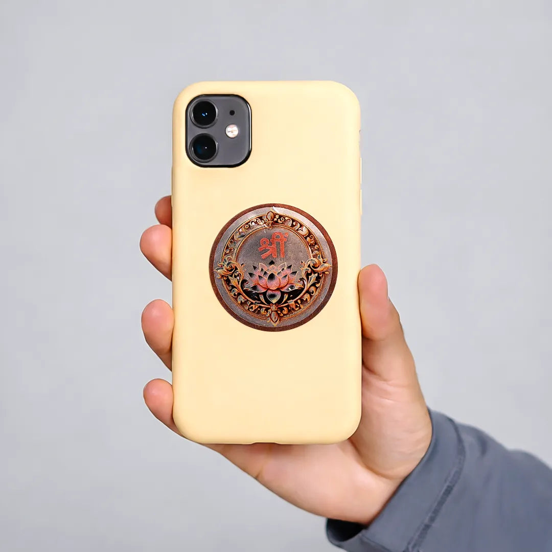 Hand holding a beige phone case with a decorative emblem on a gray background