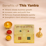 Gold-plated yantra with candles, powders, and a lamp on a beige background