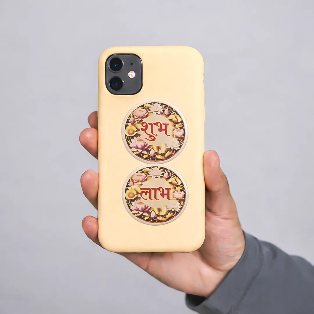 Hand holding a yellow phone case with floral designs and text on a gray background