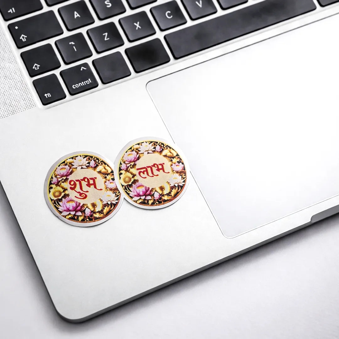 Two round coasters with floral designs and text on a laptop keyboard.Shubh Labh Sticker (Pack of 10pcs) - Auspicious Prosperity Symbol