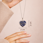 Heart-shaped pendant necklace with measurements on a plain background