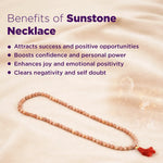 Sunstone necklace with benefits listed on a sand background