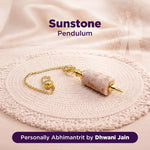 Sunstone pendulum on a textured surface with 'Sunstone' and 'Dhwani Jain' text.