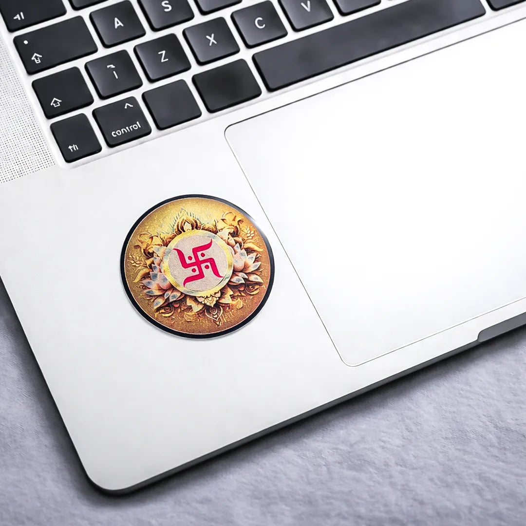 Laptop with a circular sticker featuring a swastika design on the palm rest area.