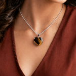 Necklace with a heart-shaped pendant worn by a person in a red garment