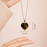 Heart-shaped pendant necklace with measurement details on a beige background