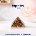 Tiger Eye Pyramid with a person in a meditative pose on a white background