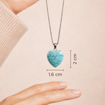 Turquoise heart-shaped pendant on a chain with measurements shown against a beige background
