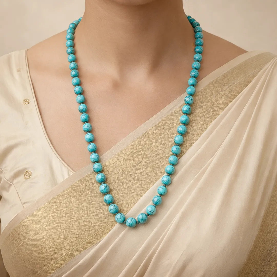 Turquoise beaded necklace worn by a person in a beige outfitTurquoise Necklace for Protection, Communication & Emotional Balance