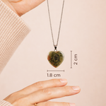 Heart-shaped pendant necklace with measurements on a beige background