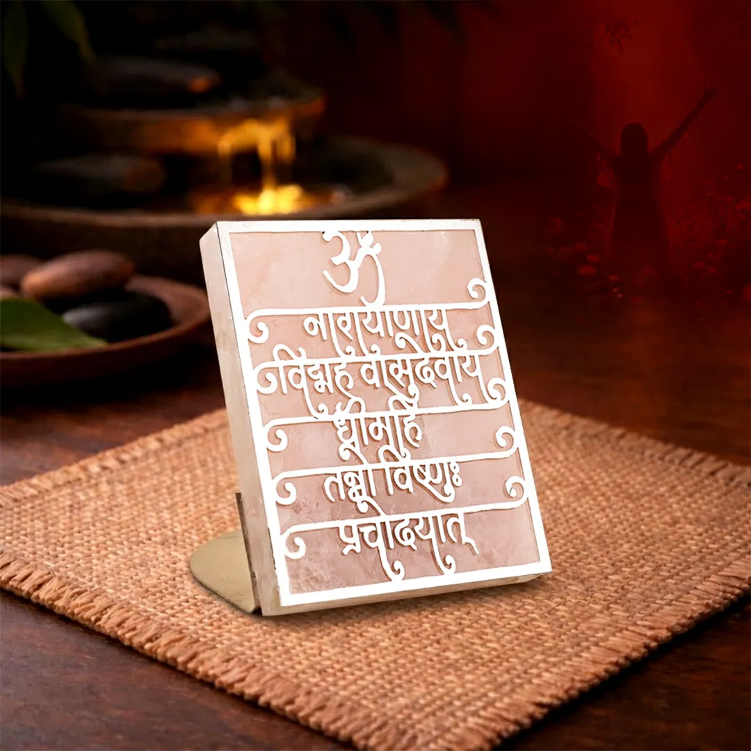 Decorative sign with engraved text on a wooden stand, placed on a textured surface.