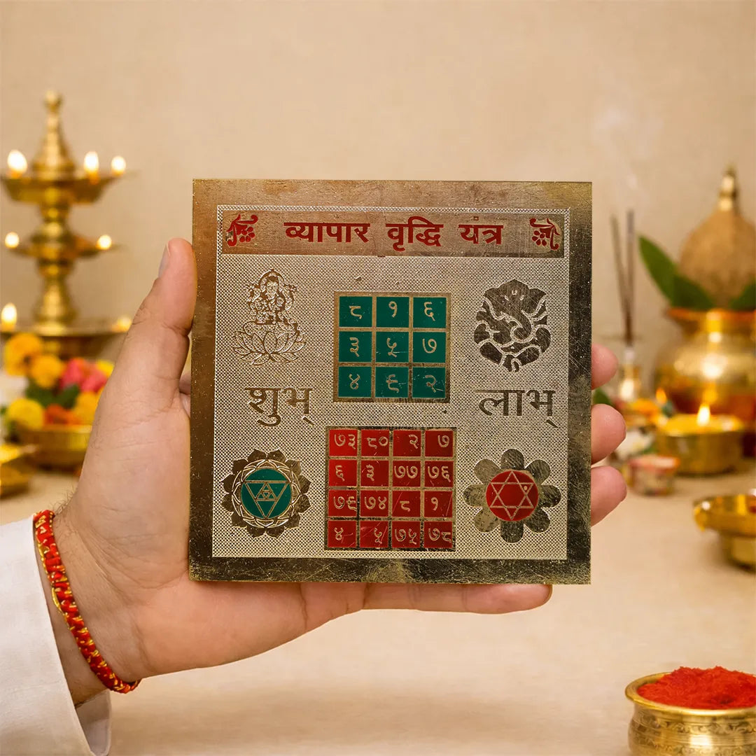 Hand holding a decorative card with symbols and text against a blurred background of religious items.