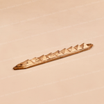 A small metallic bronze-colored decorative piece with a series of triangular pyramid-like facets, photographed on a plain beige background.