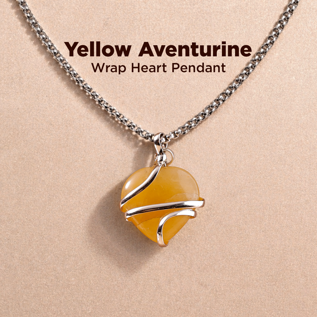 Yellow aventurine wrap heart pendant on a chain against a beige background