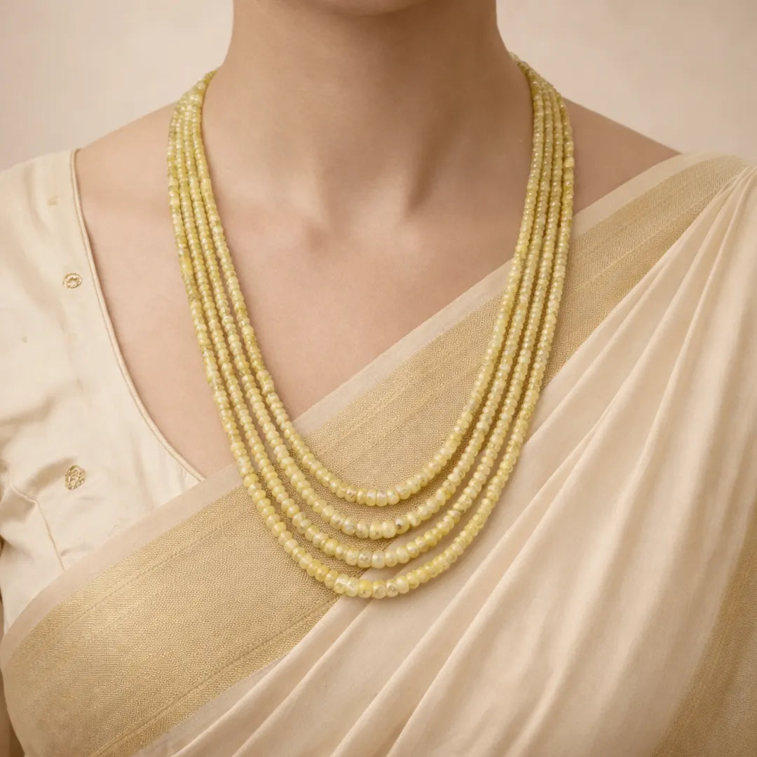 Woman wearing a beige saree with a yellow beaded necklaceYellow Sapphire 4 Line Necklace for Wealth, Success & Prosperity