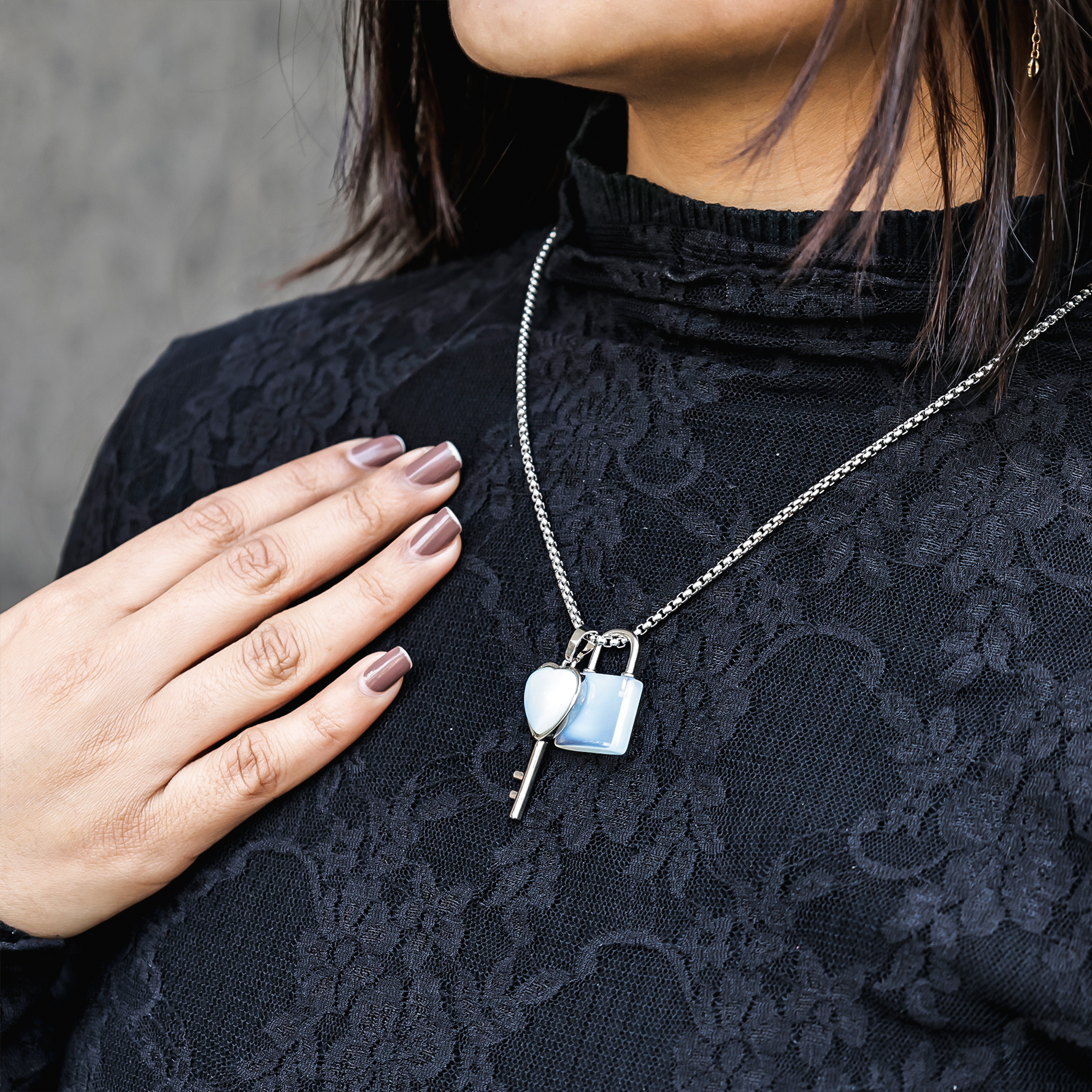 Person wearing a black lace top with a silver necklace featuring a lock and key pendant.Opalite Lock And Key Pendant - Abhimantrit & Certified